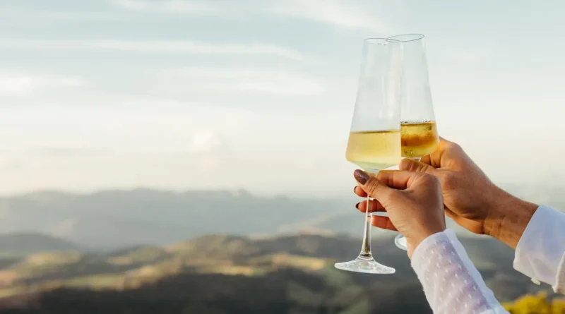 Duas taças de espumante lado a lado na mesa de um casamento, com luzes quentes e desfoque ao fundo