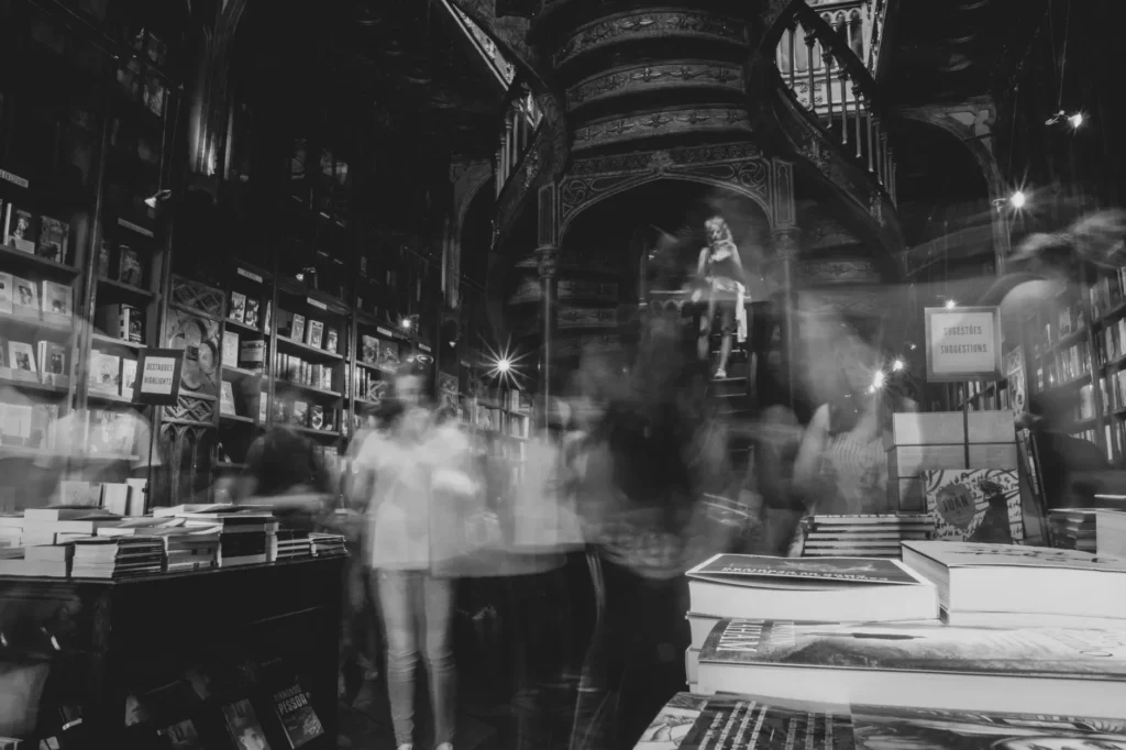 Interior de uma livraria antiga com estantes de livros até ao teto iluminadas por luz dourada de outono