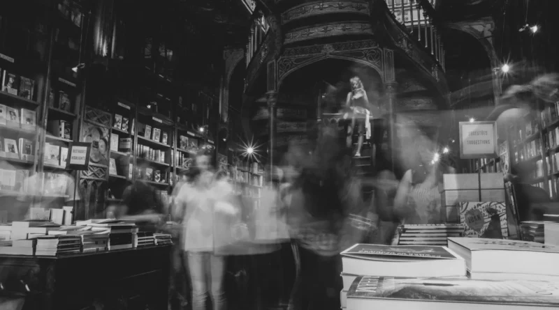 Interior de uma livraria antiga com estantes de livros até ao teto iluminadas por luz dourada de outono