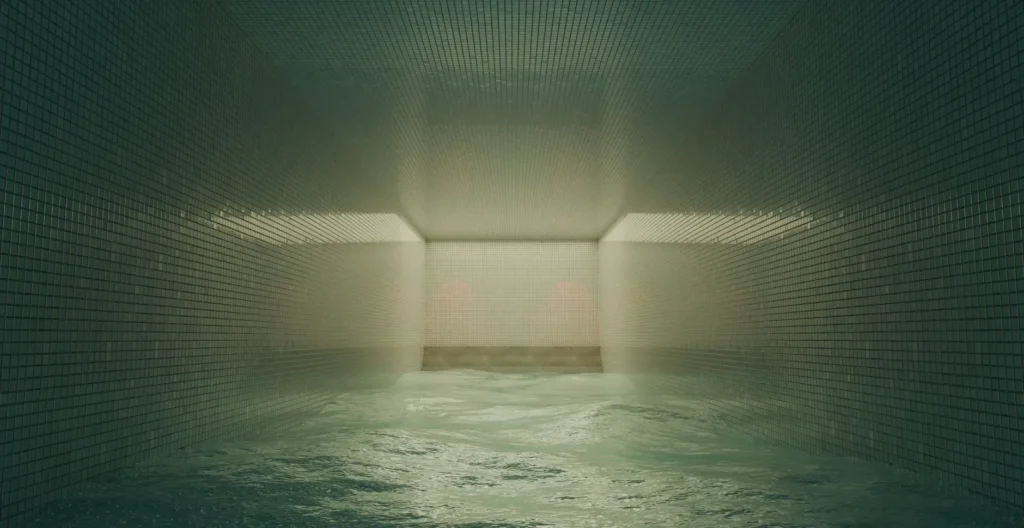 Piscina de ginásio vazia ao anoitecer, com raias flutuando e luz quente refletida na água parada