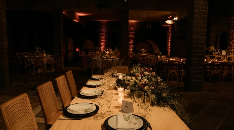 Recepção de casamento à noite com luzes quentes e copos de vinho do Porto sobre a mesa