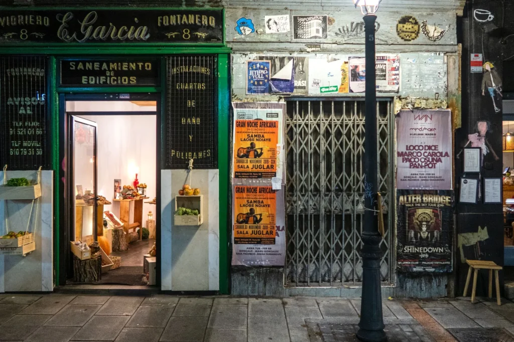 Sala de alongamento de ginásio vazia ao anoitecer, com colchonetes organizados, luz baixa e chuva na janela, ambiente frequentado apenas por adultos