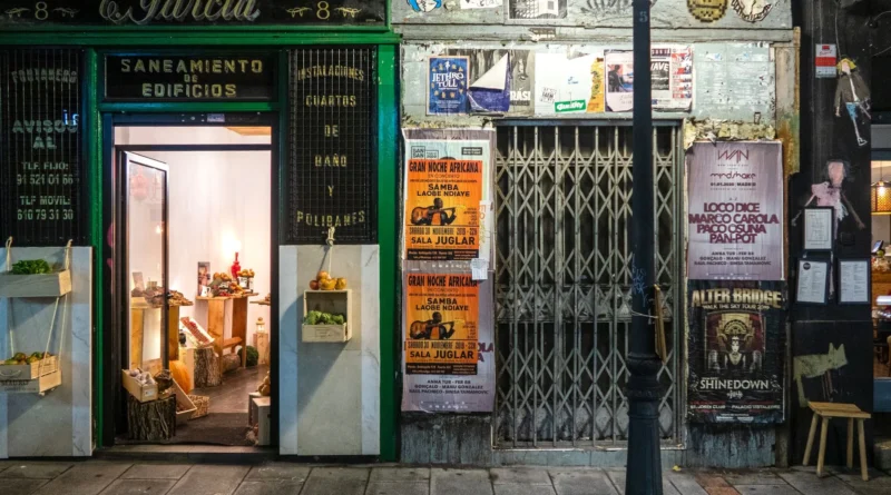 Sala de alongamento de ginásio vazia ao anoitecer, com colchonetes organizados, luz baixa e chuva na janela, ambiente frequentado apenas por adultos